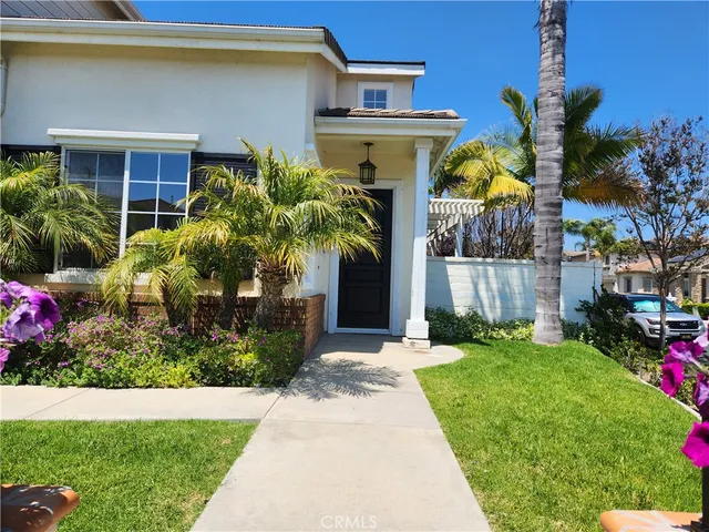 a front view of house and yard with beautiful flowers and green space