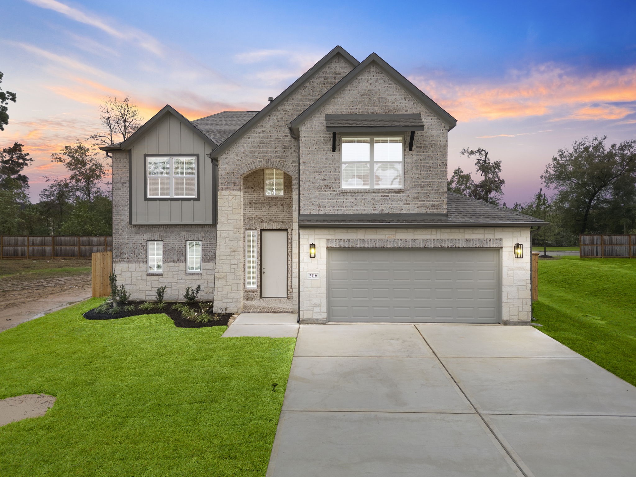a front view of a house with a yard and trees