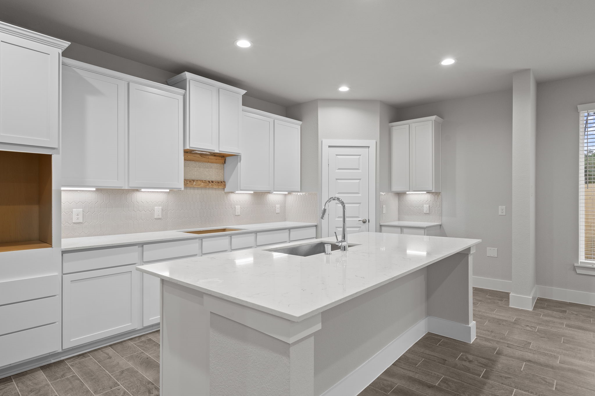 2116 Golden Spruce Court Conroe, TX 77301 - Photo 2 of 28 a kitchen with kitchen island a sink a center island and cabinets