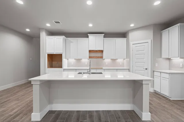 a kitchen with kitchen island cabinets and refrigerator