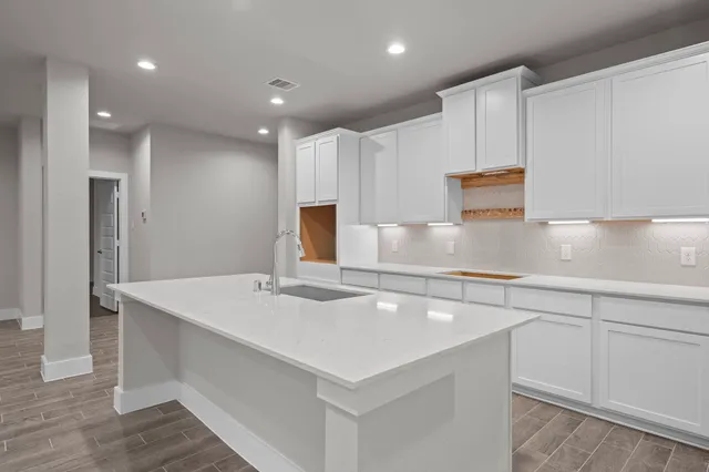 a kitchen with kitchen island a sink appliances and cabinets