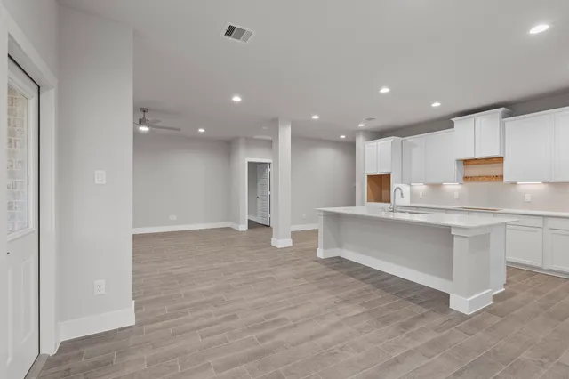 a view of kitchen with center island and stainless steel appliances wooden floor