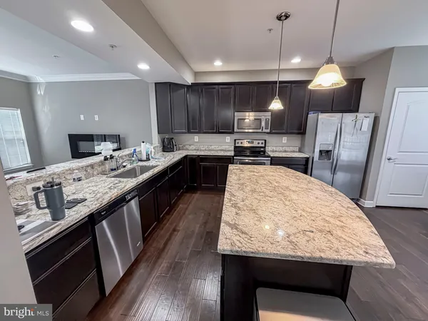 a kitchen with kitchen island granite countertop wooden cabinets a dining table and chairs