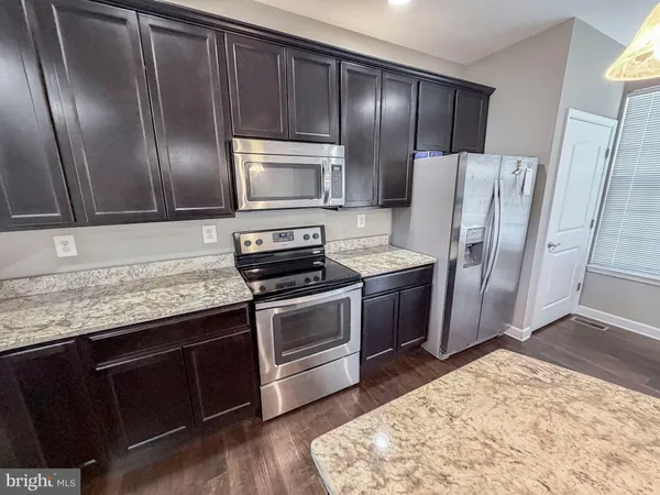 a kitchen with stainless steel appliances granite countertop a refrigerator and a sink