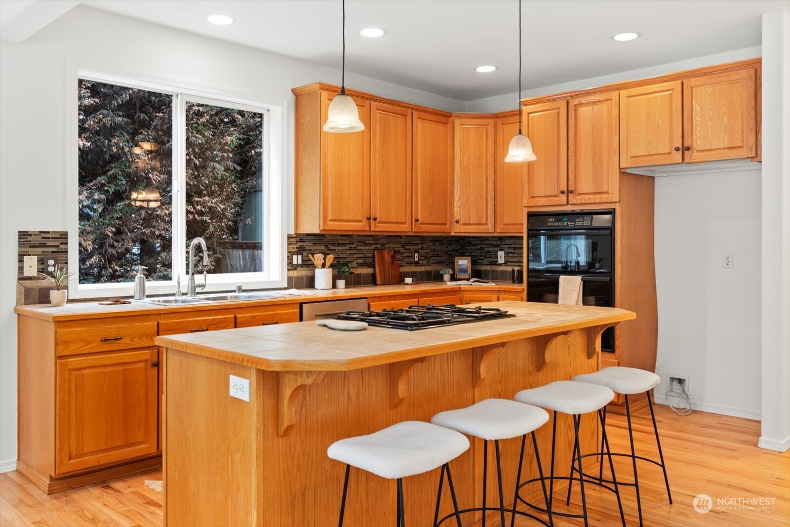 22920 53rd Avenue Southeast Bothell, WA 98021 - Photo 8 of 40 a kitchen with stainless steel appliances granite countertop a stove a refrigerator a sink a dining table and chairs with wooden floor