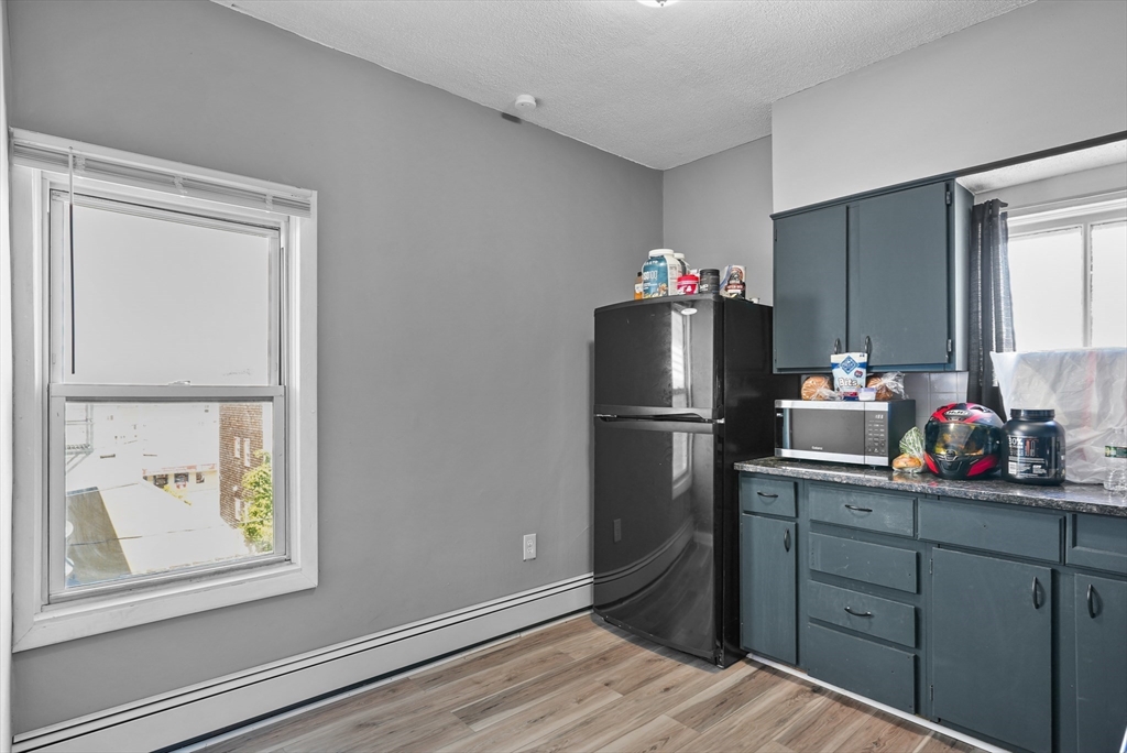 32 Quequechan Street Fall River, MA 02723 - Photo 16 of 34 a kitchen with a refrigerator and a window
