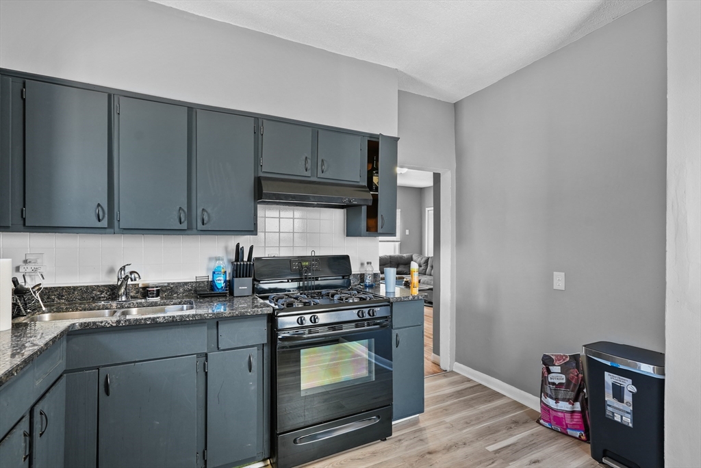 32 Quequechan Street Fall River, MA 02723 - Photo 17 of 34 a kitchen with stainless steel appliances granite countertop a sink stove and cabinets
