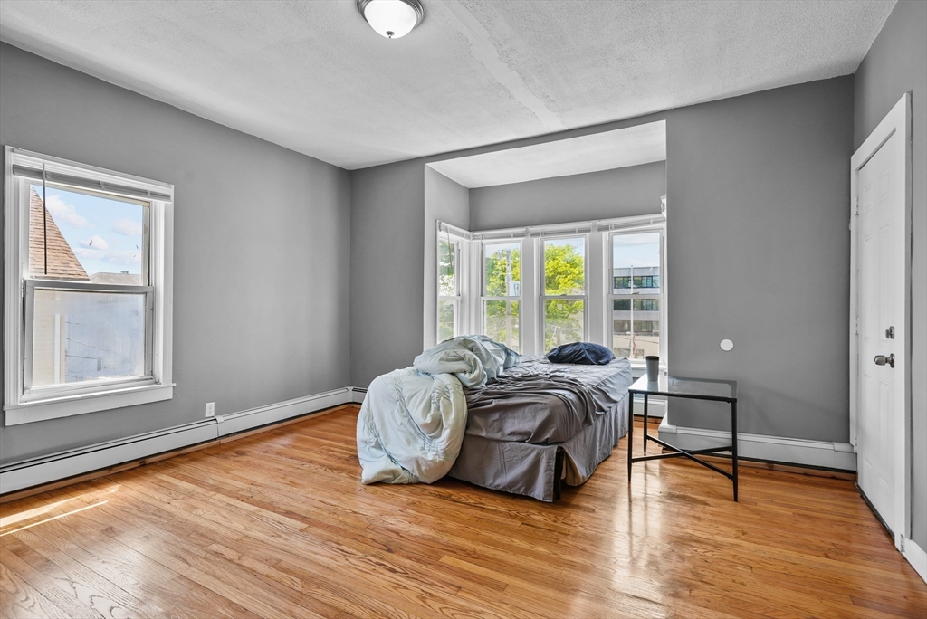 32 Quequechan Street Fall River, MA 02723 - Photo 20 of 34 a spacious bedroom with a bed and wooden floor