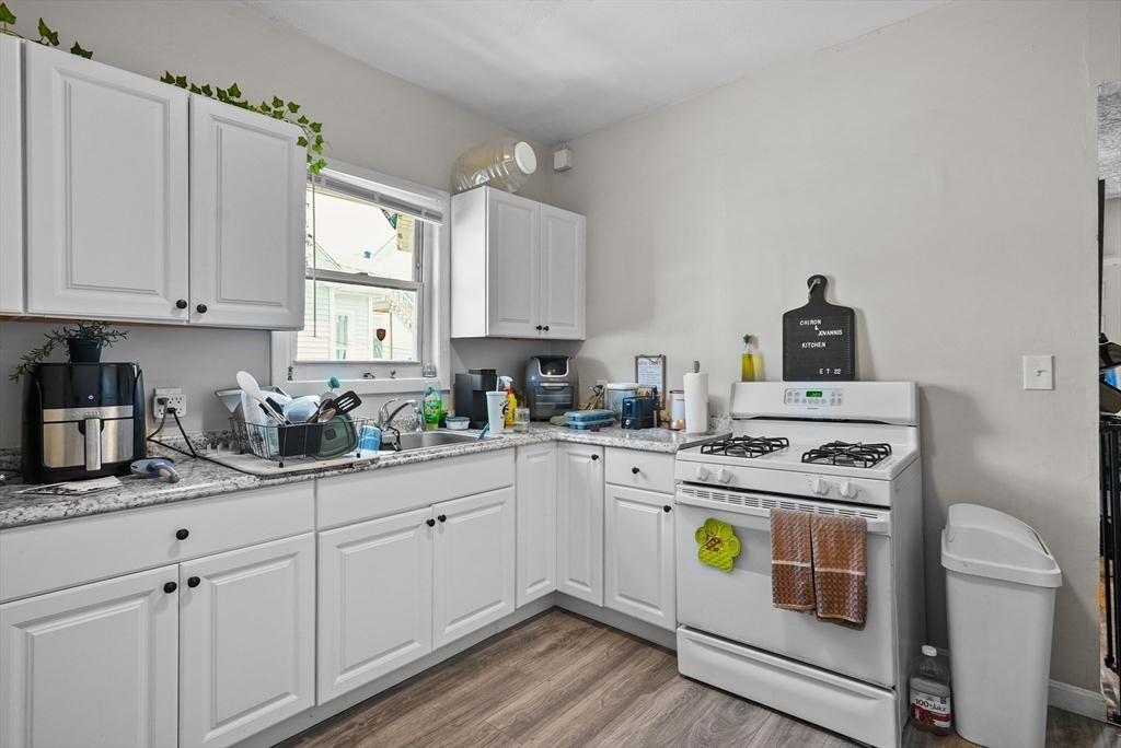 32 Quequechan Street Fall River, MA 02723 - Photo 4 of 34 a kitchen with a white cabinets and white appliances