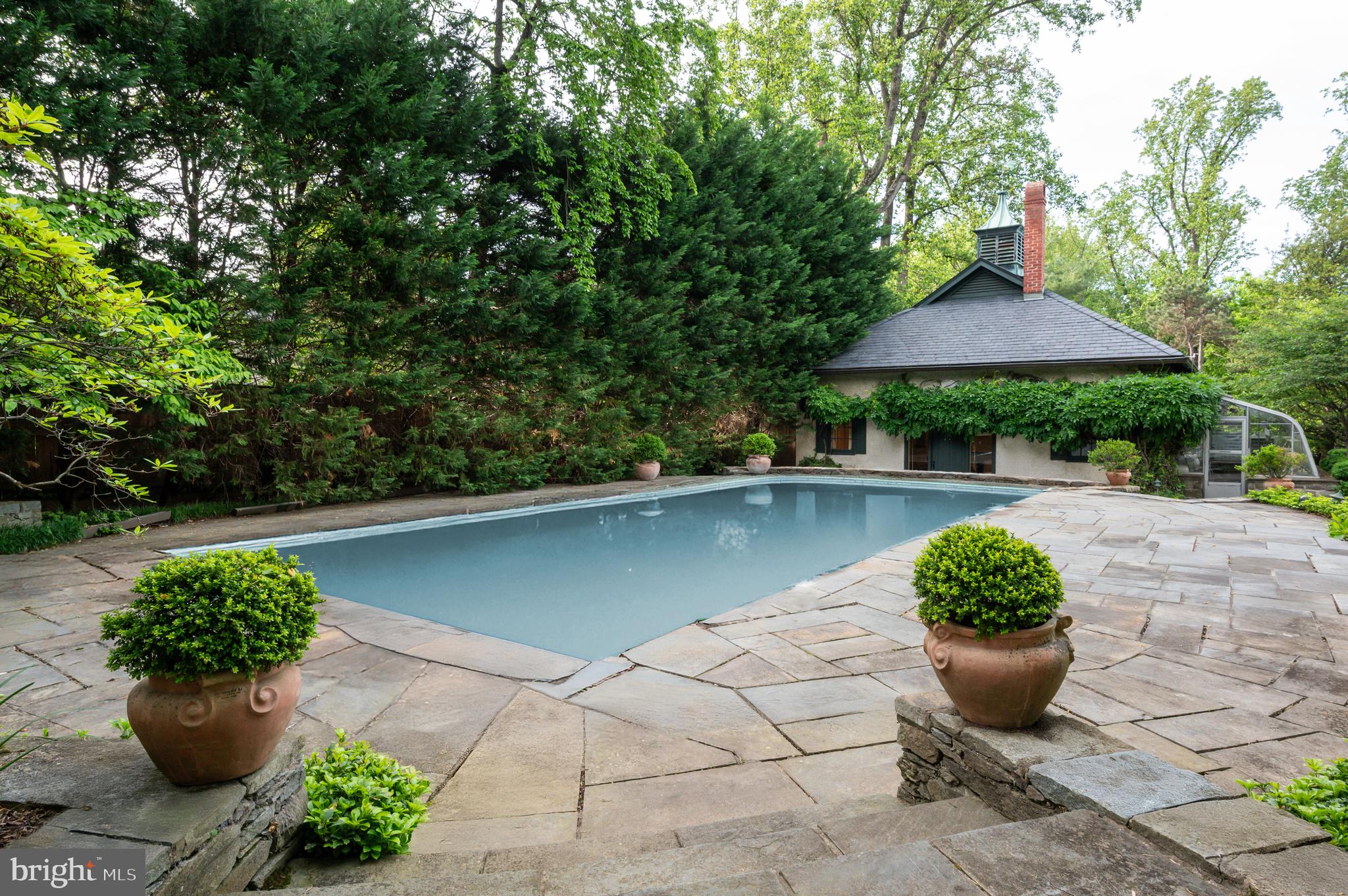 7116 Glenbrook Road Bethesda, MD 20814 - Photo 15 of 30 a front view of a house with a yard and potted plants