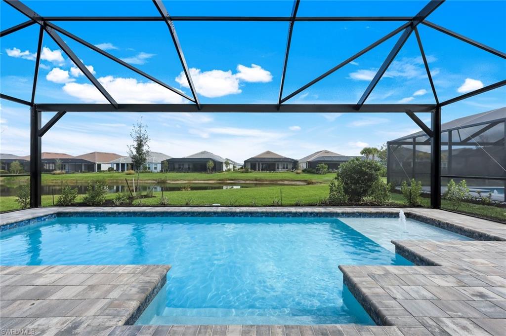 15804 Derna Street Naples, FL 34114 - Photo 1 of 28 Swimming pool with a sunroom, glass enclosure, a residential view, and a patio