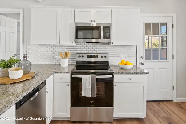 a kitchen with stainless steel appliances a stove a microwave a sink and cabinets