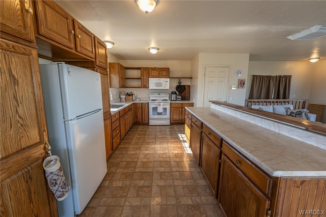 180 Sunfish Way Meadview, AZ 86444 - Photo 13 of 42 a kitchen with stainless steel appliances granite countertop a refrigerator a stove and a sink