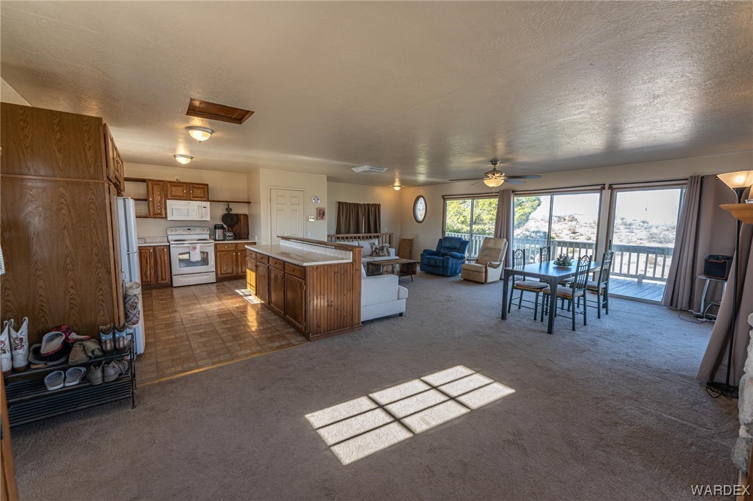180 Sunfish Way Meadview, AZ 86444 - Photo 15 of 42 a open kitchen with stainless steel appliances granite countertop a refrigerator stove oven dining table chairs and a large window with the garden view