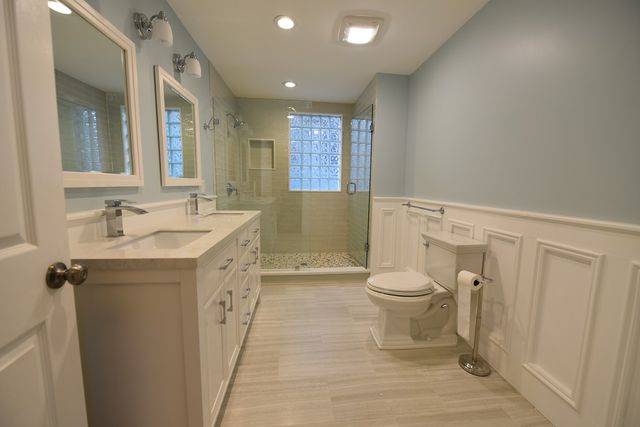 a bathroom with a double vanity sink toilet and shower