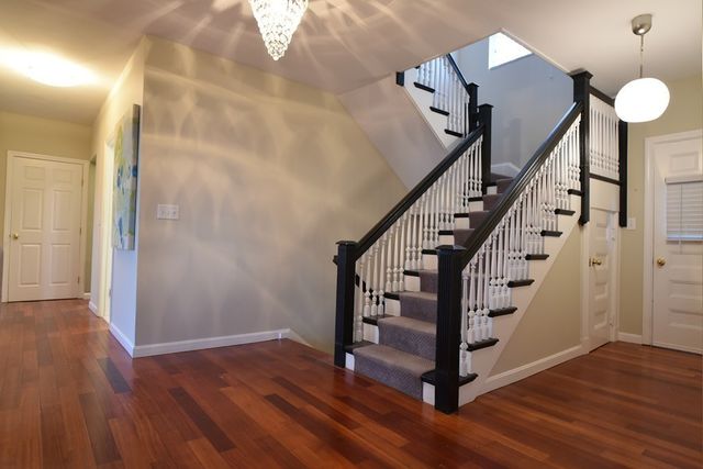 a view of a hallway with wooden floor and stairs