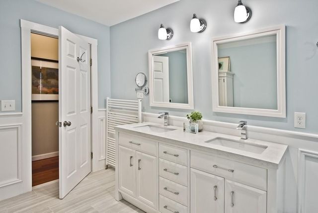 a bathroom with double vanity sinks a mirror and a shower
