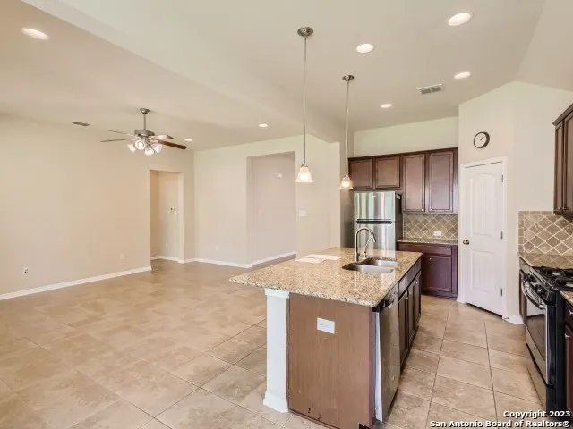 a kitchen with kitchen island a sink stainless steel appliances and cabinets