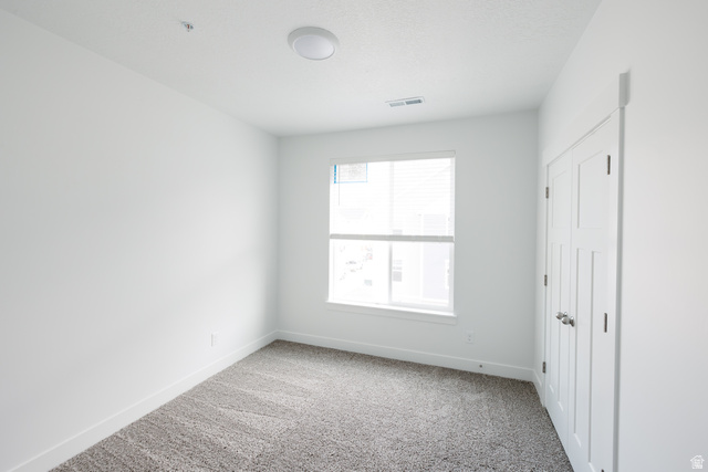 4653 South Alder Drive, Unit H303 Mapleton, UT 84664 - Photo 9 of 15 Empty room featuring light carpet and baseboards