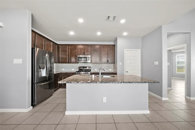 a large kitchen with a stove a refrigerator and a sink