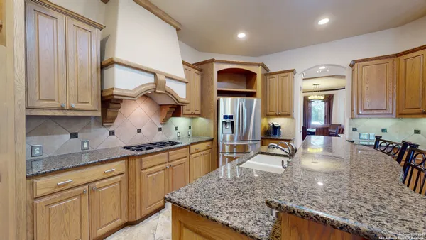 a kitchen with stainless steel appliances granite countertop a sink stove and cabinets