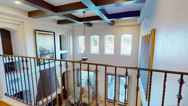 a view of staircase with lots of frames on wall and a window