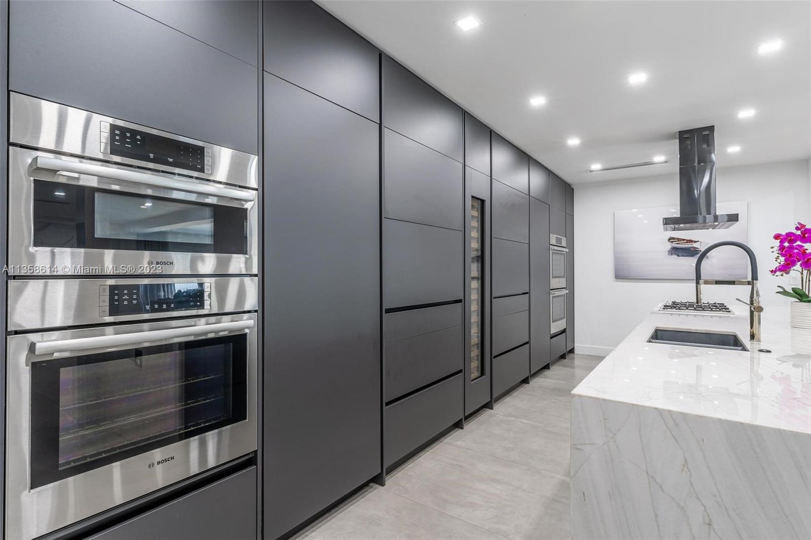 a kitchen with stainless steel appliances kitchen island granite countertop a stove a microwave and a refrigerator