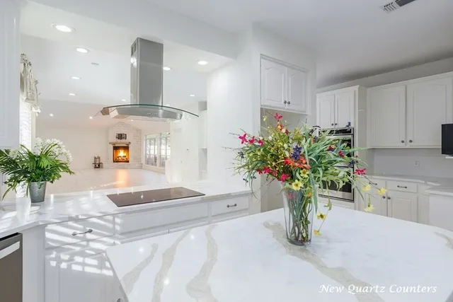 a white vase with white and yellow flowers