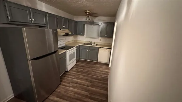 a kitchen with granite countertop a refrigerator and a sink