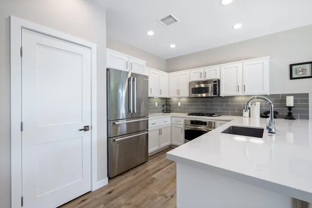 a bedroom with a large bed and a chandelier