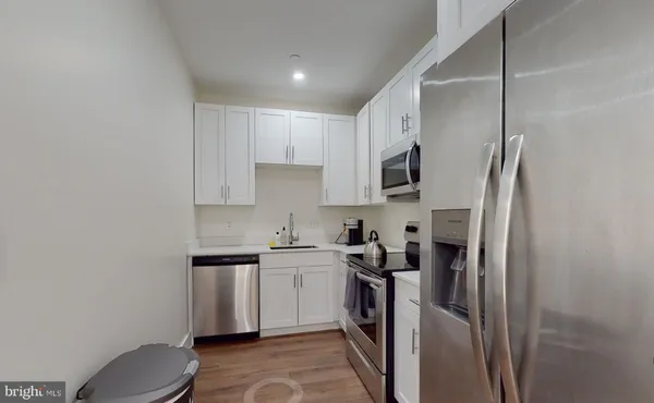a kitchen with stainless steel appliances a sink stove and refrigerator