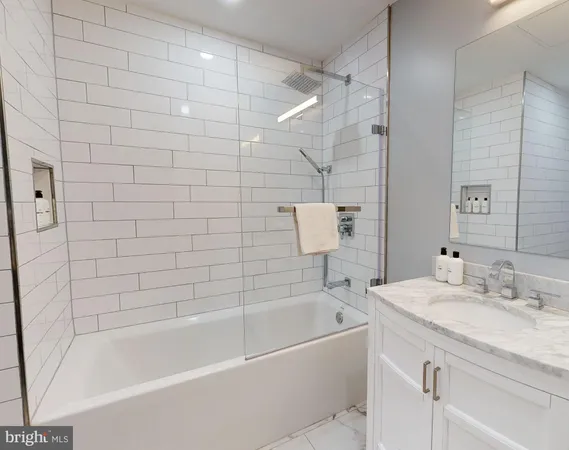 a bathroom with a granite countertop bathtub shower sink and mirror