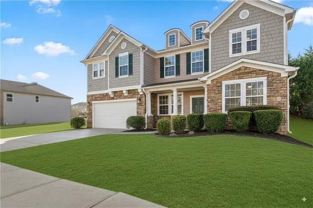 a front view of a house with a yard and garage