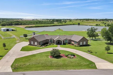 an aerial view of a house with outdoor space and a lake view