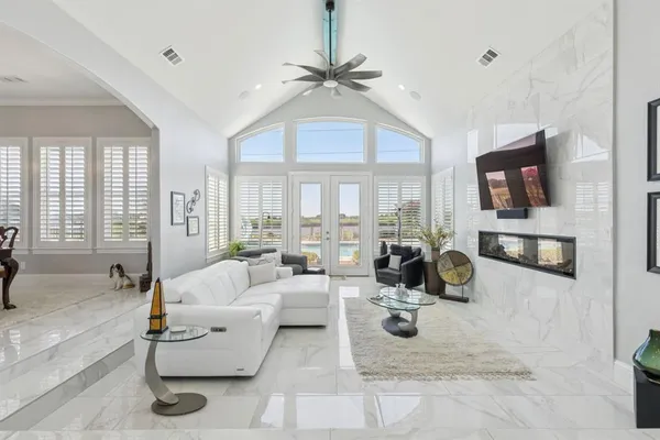 a living room with furniture a flat screen tv and a large window