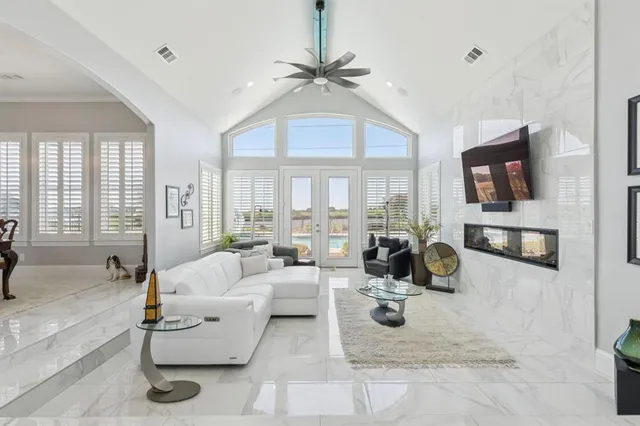 a living room with furniture a flat screen tv and a large window