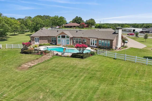 a aerial view of a house with swimming pool and a yard