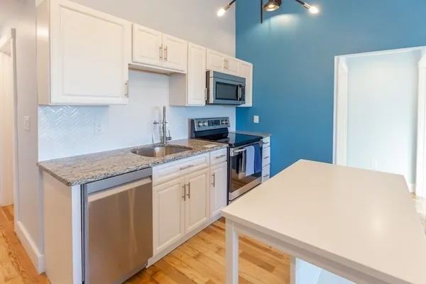 a kitchen with stainless steel appliances a sink a stove a microwave a counter top space