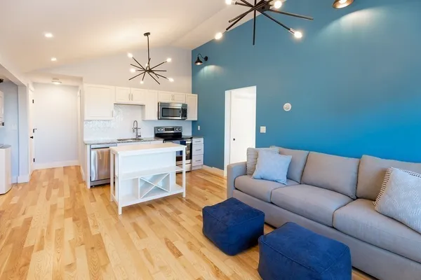 a living room with kitchen island furniture and a chandelier