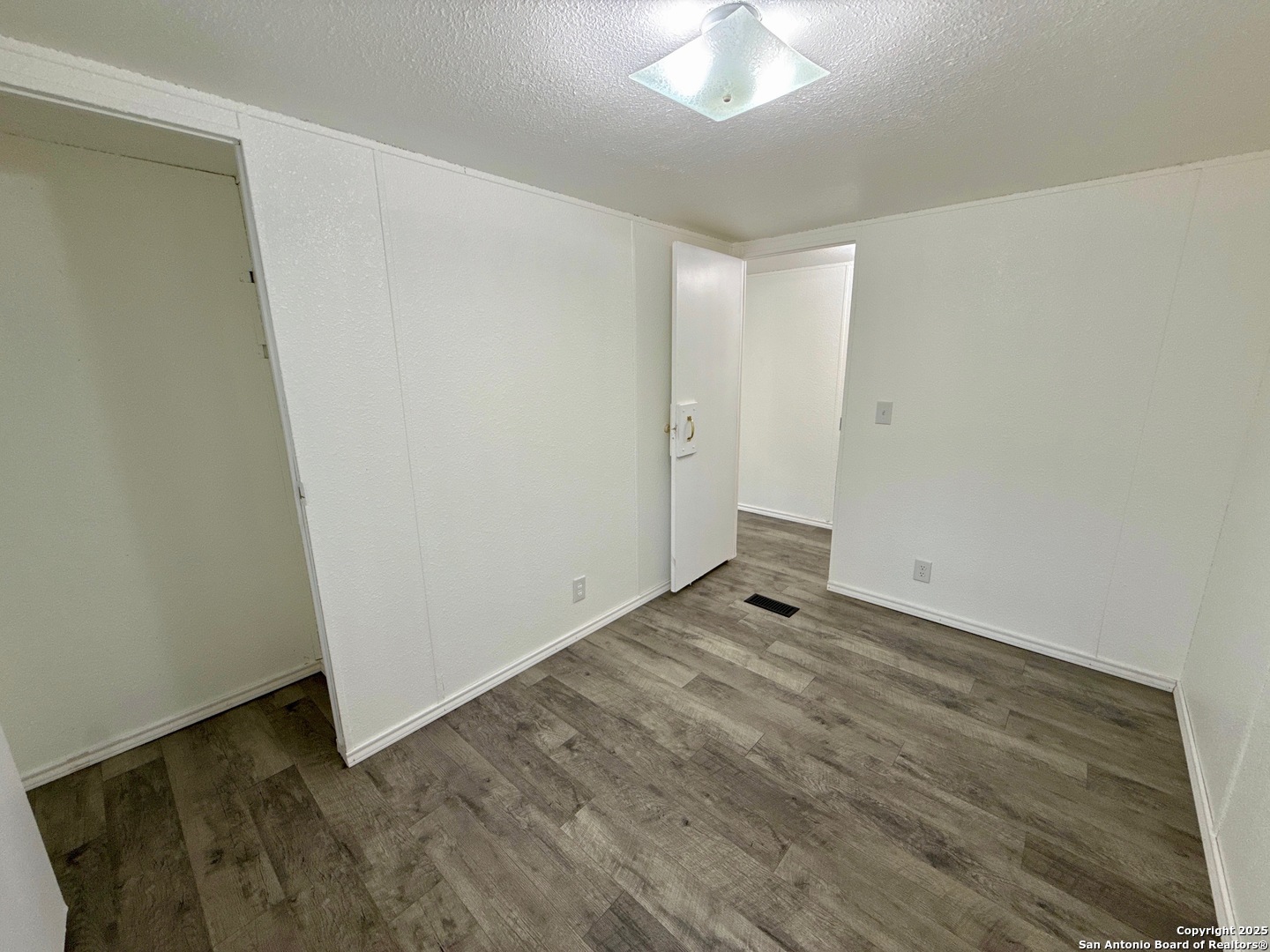 300 Pecos Road Bandera, TX 78003 - Photo 18 of 44 an empty room with wooden floor and fan