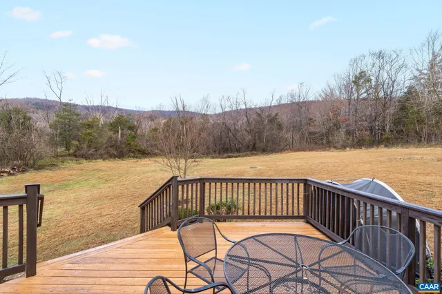 a view of a roof deck with wooden floor and fence with a bench