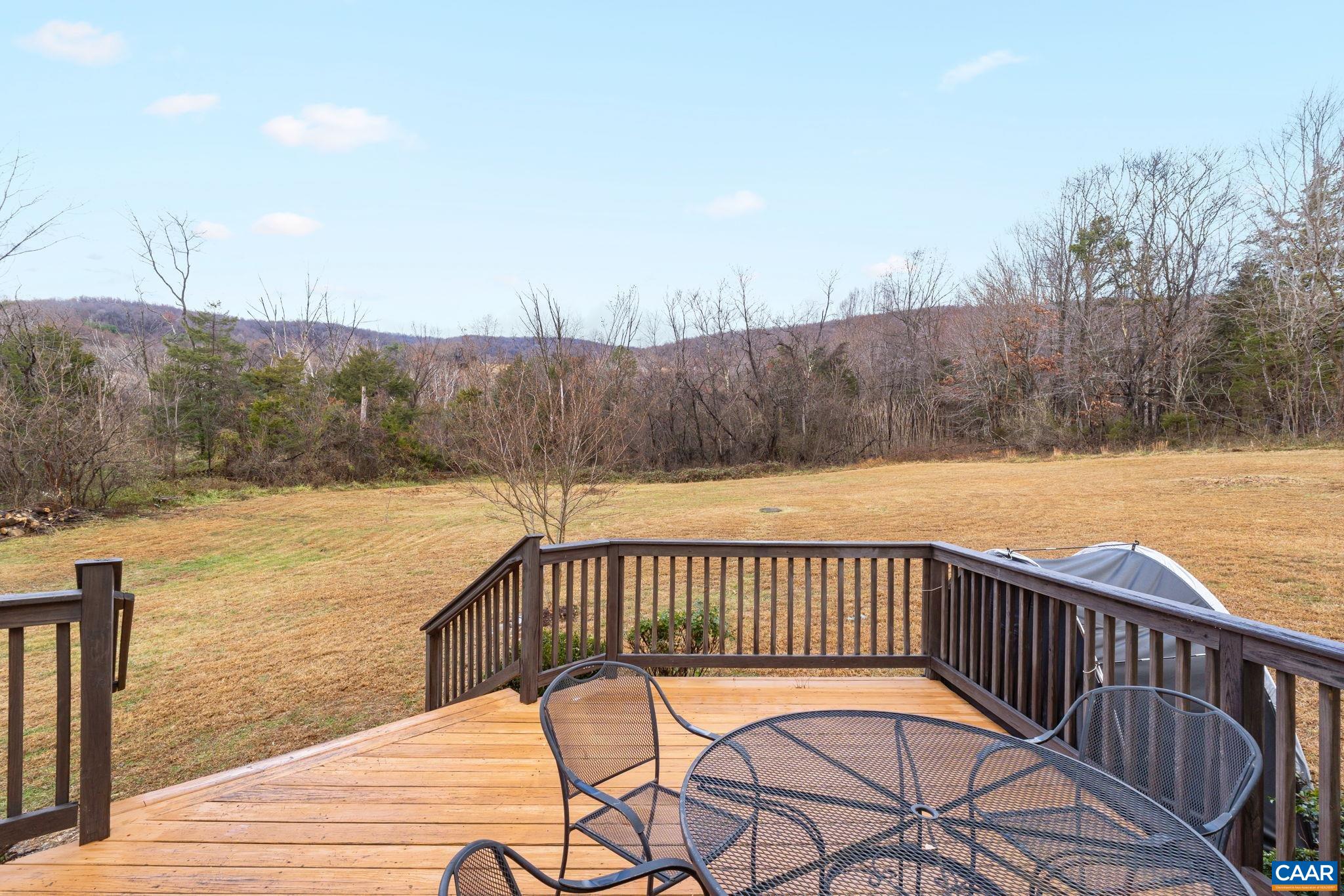 a view of a roof deck with wooden floor and fence with a bench