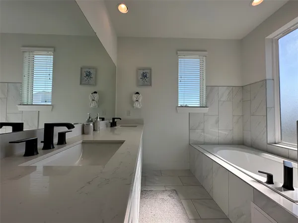 a bathroom with a tub a sink and a window