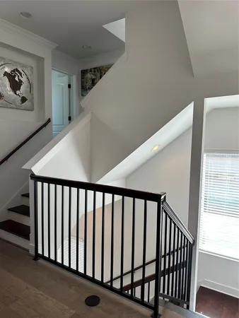 a view of staircase with railing and white walls