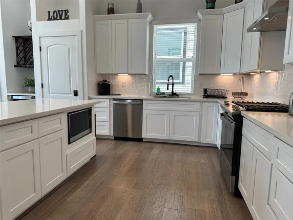 a kitchen with granite countertop white cabinets and white appliances