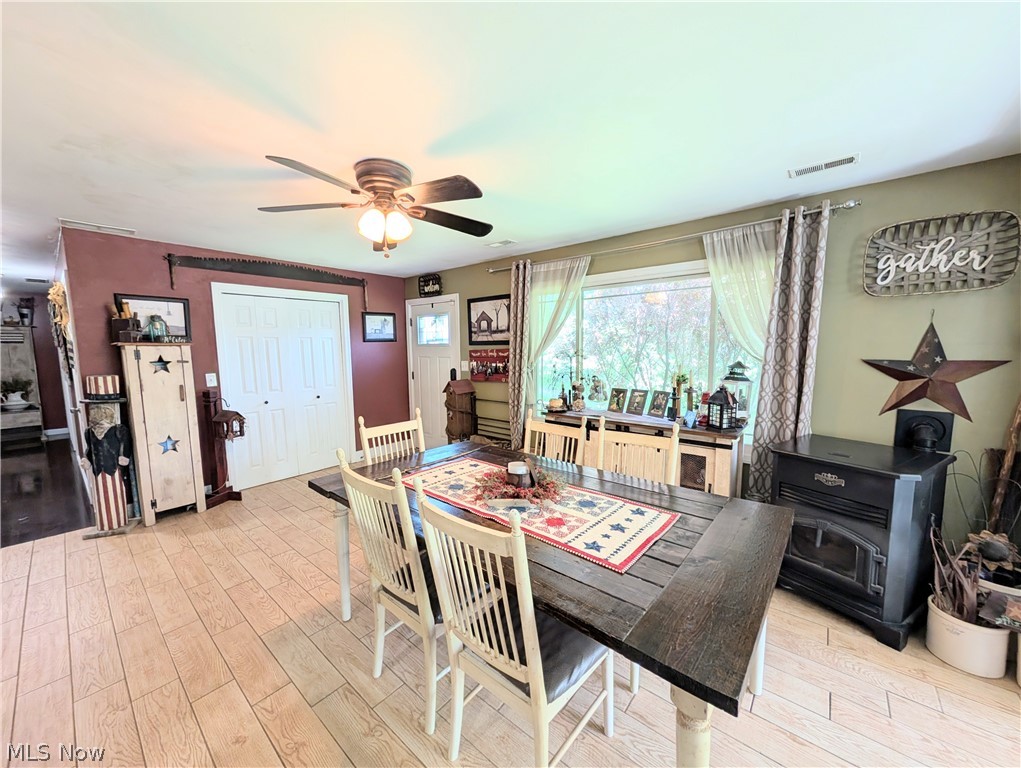 6700 McCaslin Road Nashport, OH 43830 - Photo 17 of 30 Dining area featuring wood-finish flooring, a ceiling fan with integrated lighting, and a large window overlooking exterior trees