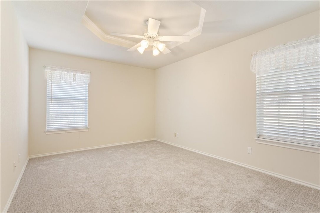 306 Baker Lane Robinson, TX 76706 - Photo 21 of 28 an empty room with a chandelier fan and windows