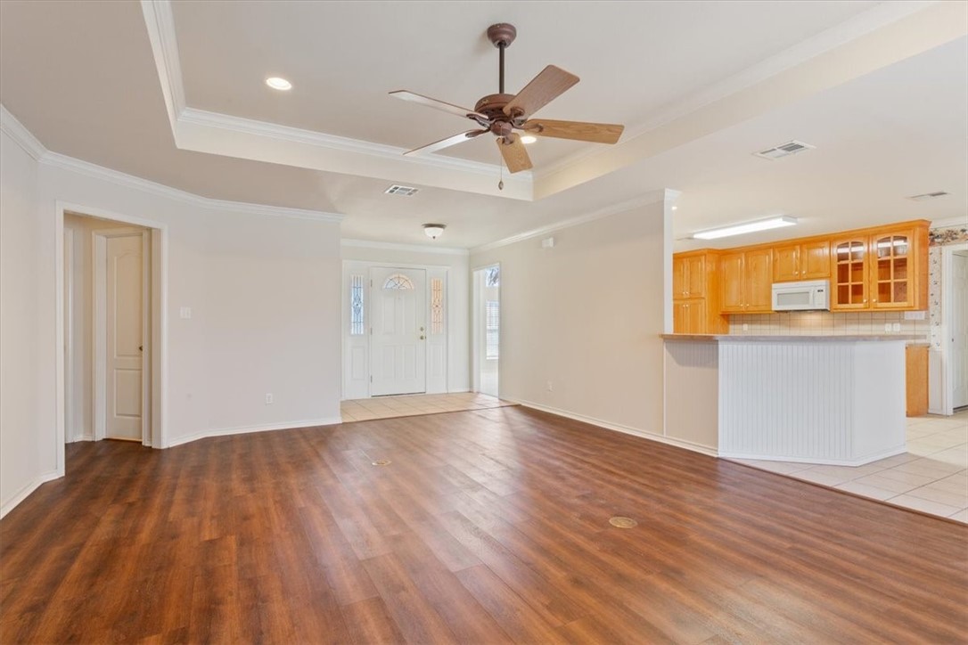 306 Baker Lane Robinson, TX 76706 - Photo 6 of 28 a view of an empty room with wooden floor and a ceiling fan