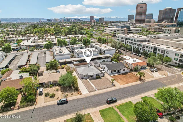 an aerial view of residential houses with outdoor space and parking