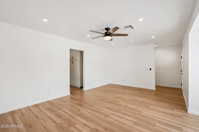 an empty room with fan and windows
